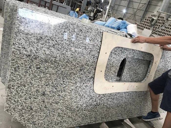 Tiger Skin White granite countertop during sink cutout fabrication Tiger Skin White granite countertop during sink cutout fabrication